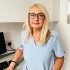 Blond lekarka w okularach i niebieskiej bluzce