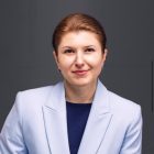 Kobieta w fioletowej marynarce i granatowej bluzce