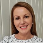 Kobieta w brązowych włosach spogląda w obiektyw